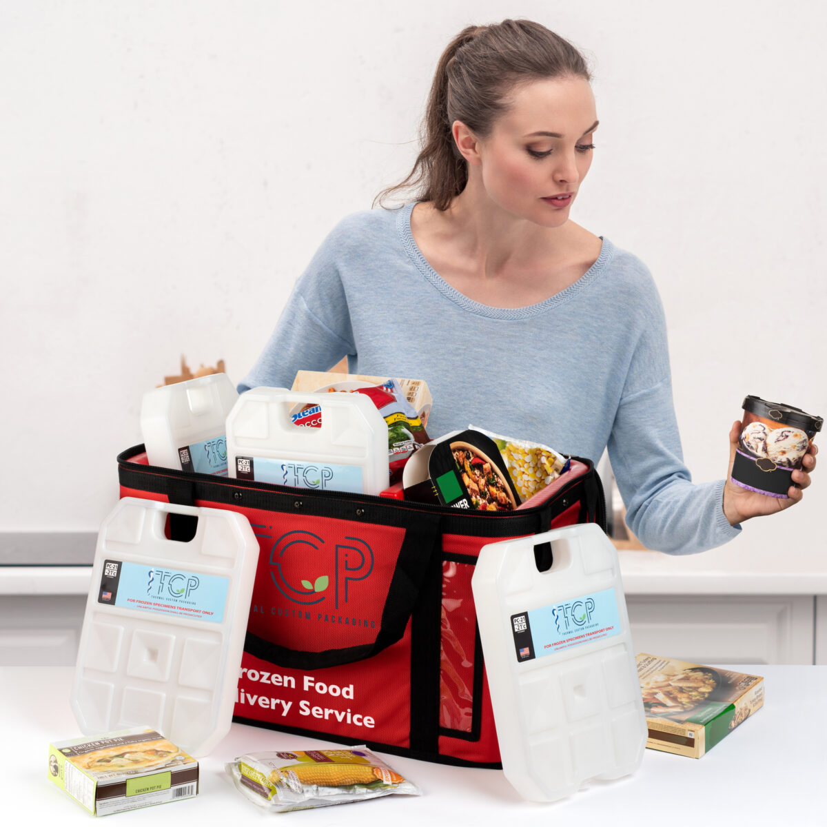 beautiful adult woman taking vegetables out of paper bag after grocery shopping